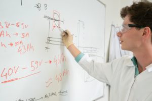 Person rechnet am Whiteboard