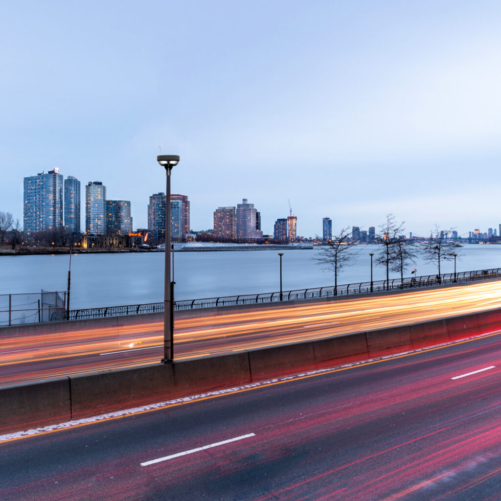 Die Straßenleuchte CIES von Televes auf einer Straße vor der Skyline einer Stadt.